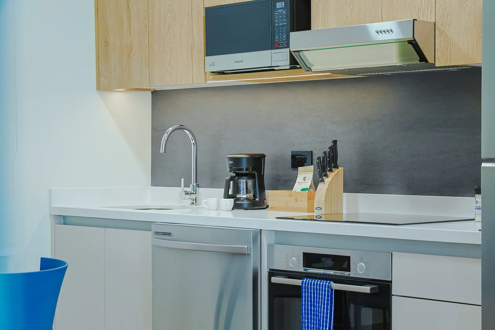 Your fully equipped kitchen features a stove, microwave, coffee maker, and sleek modern countertops—perfect for preparing meals and starting your mornings right.