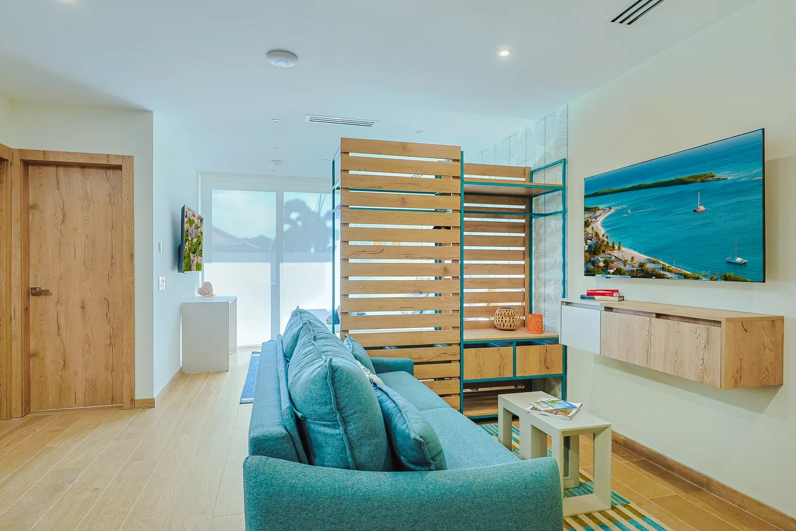 Unwind on your plush turquoise sofa while soaking in coastal vibes from the sun-drenched airy atmosphere. Modern design meets comfort in your bright, airy living space with sleek wood accents and climate control.