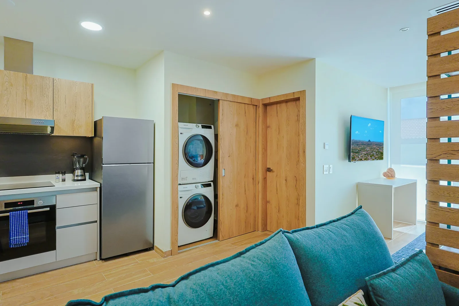Relax in your open-concept living space featuring a full kitchen, convenient in-unit laundry, and calming coastal décor, all designed to make you feel instantly at home.