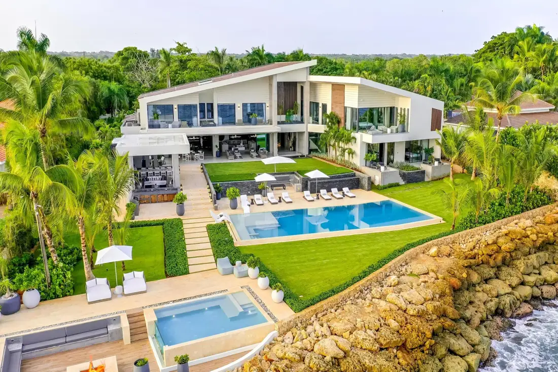 Una casa moderna con piscina está junto a una costa rocosa.