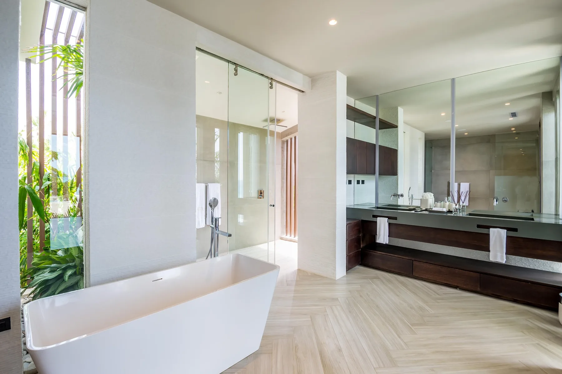 A bright bathroom with a freestanding bathtub and a wide vanity.