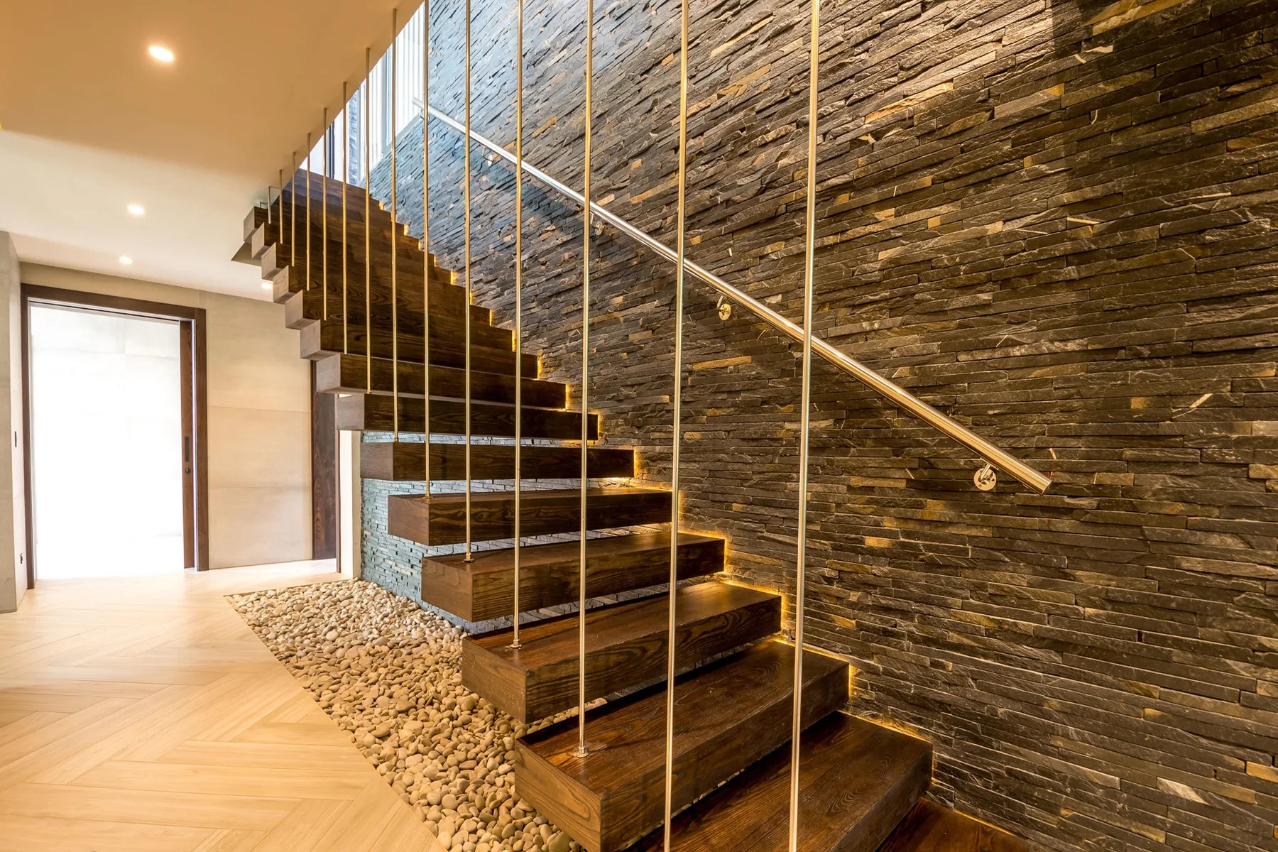 A staircase with dark wooden steps and a stone wall.