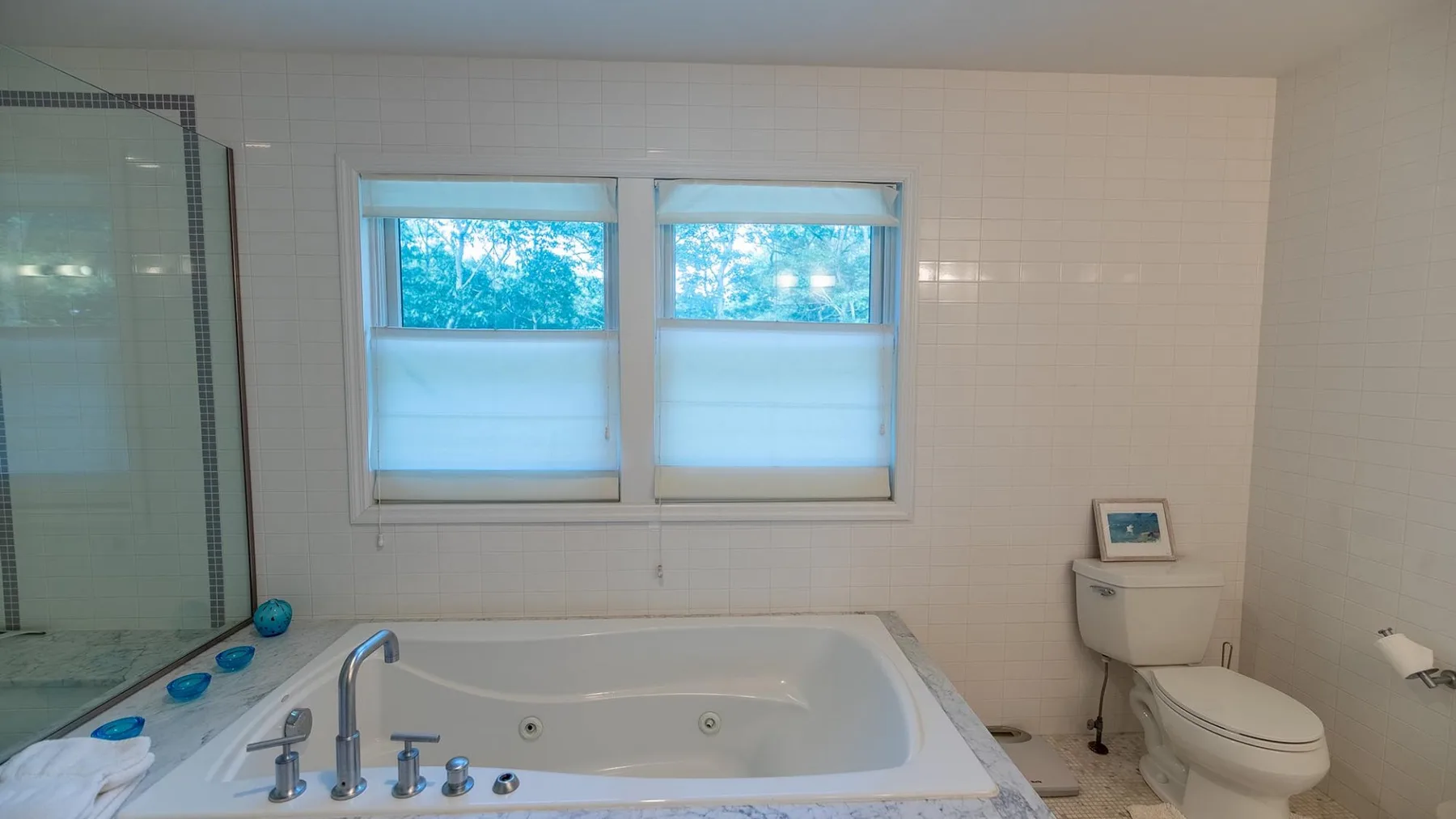 Un baño alicatado con bañera integrada, ducha e inodoro.