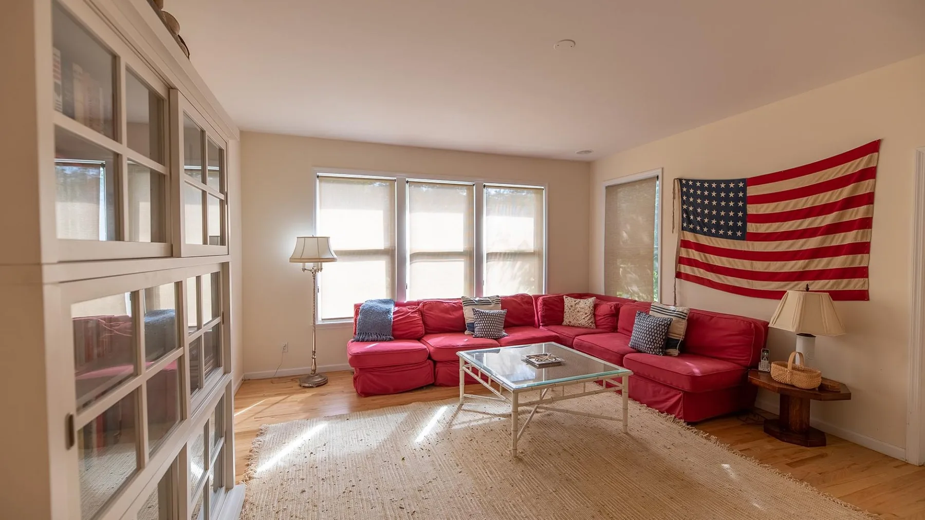 Una sala de estar con asientos modulares rojos, una mesa de centro y una bandera estadounidense.
