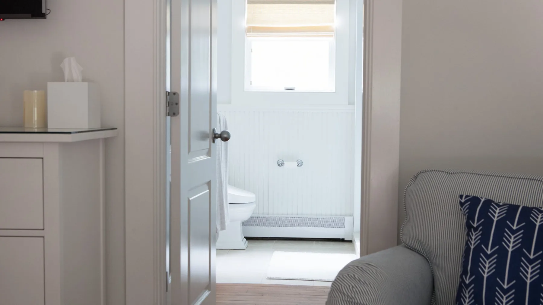 Un baño luminoso con ventana, inodoro y zona de ducha.