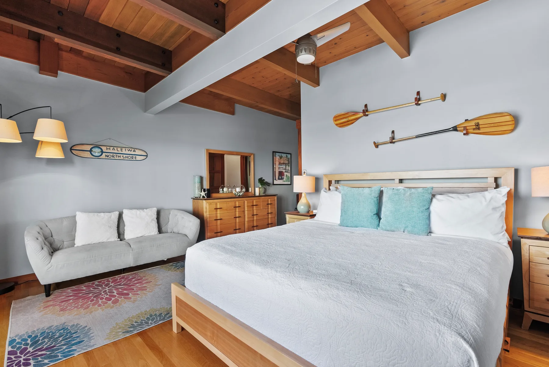Un dormitorio con una cama grande, un sofá y un techo abovedado de madera.