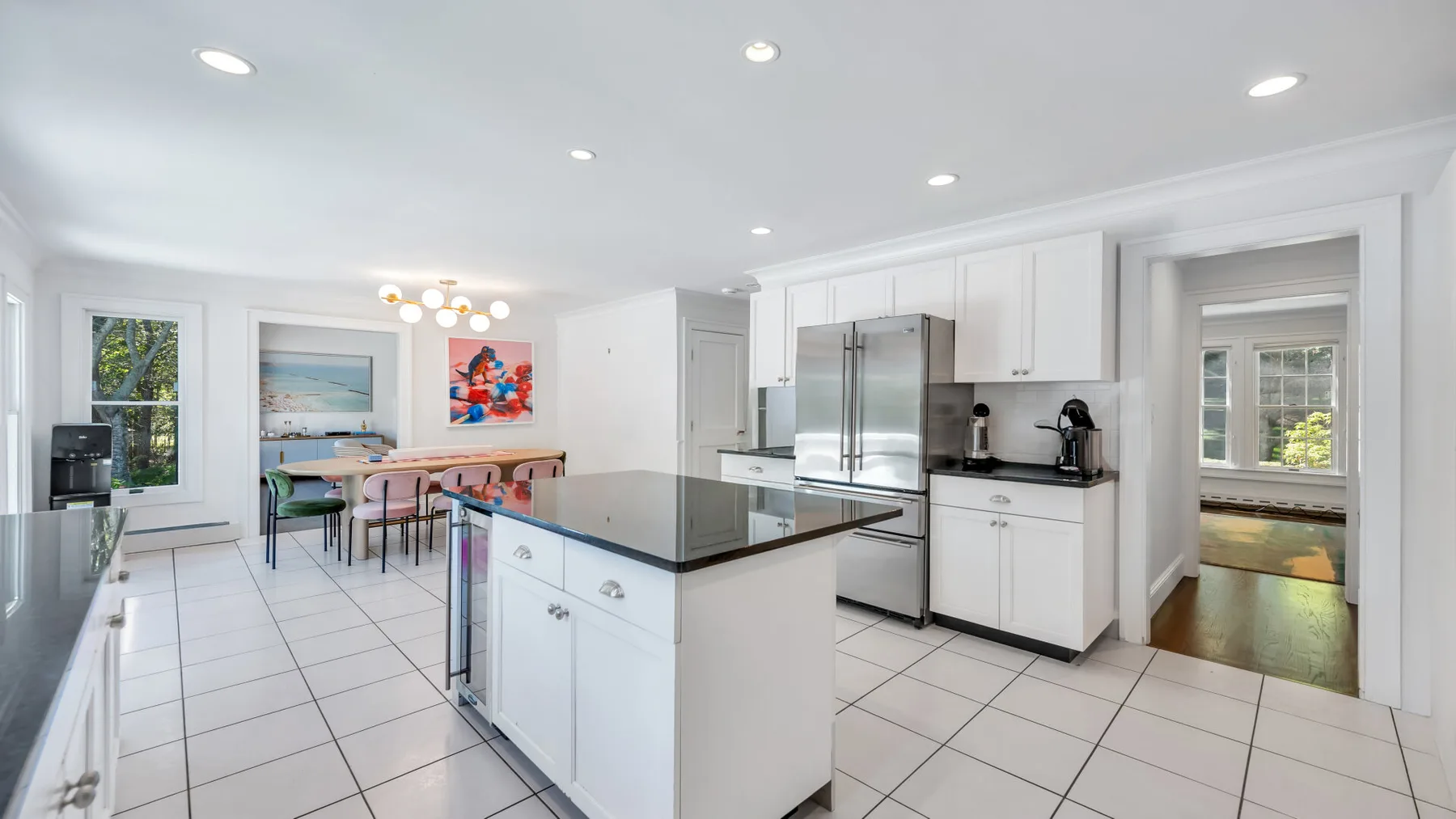 A bright kitchen with a central island and a dining table beside the windows.