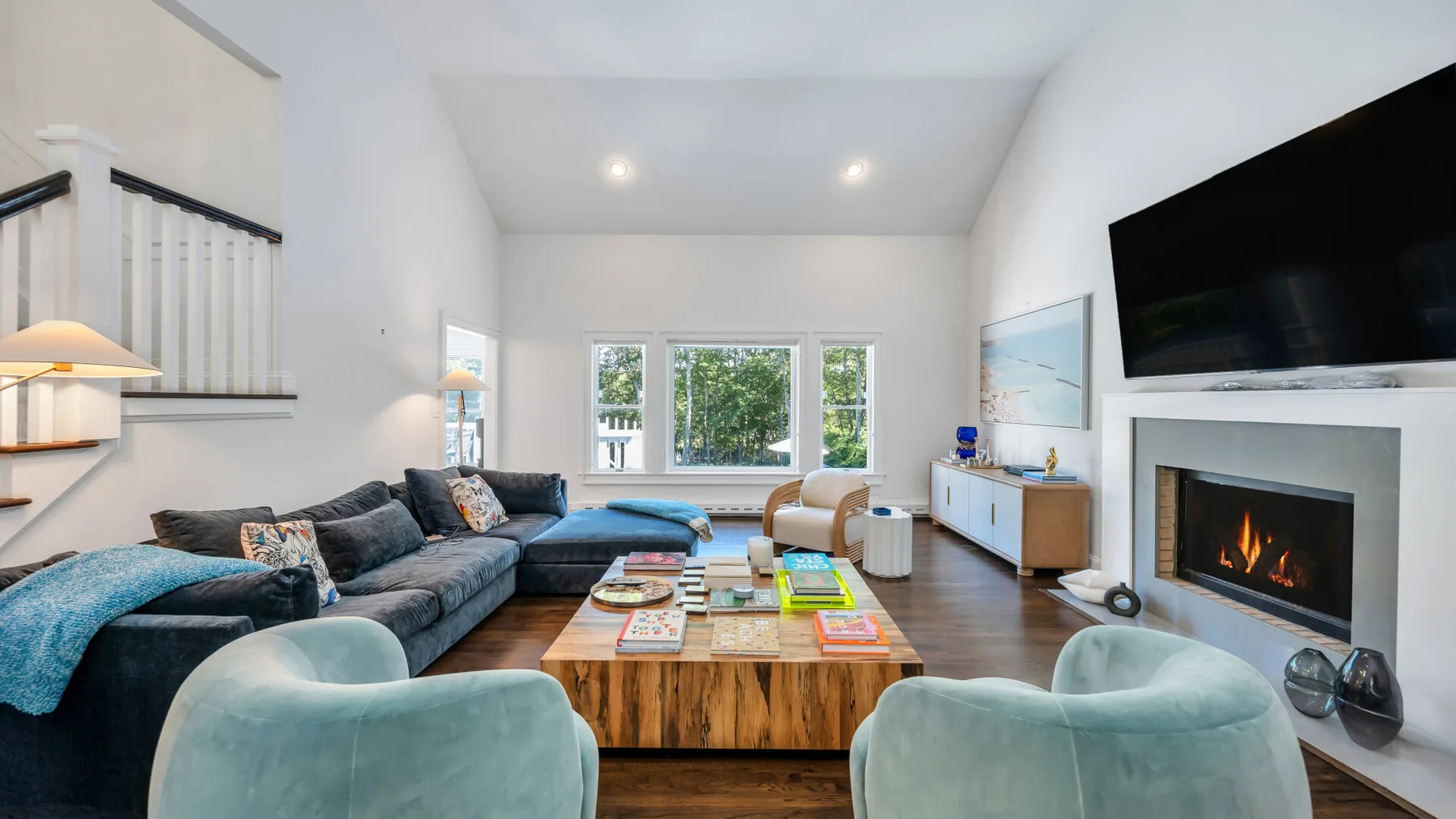 A bright living room with seating, a coffee table, and a fireplace.