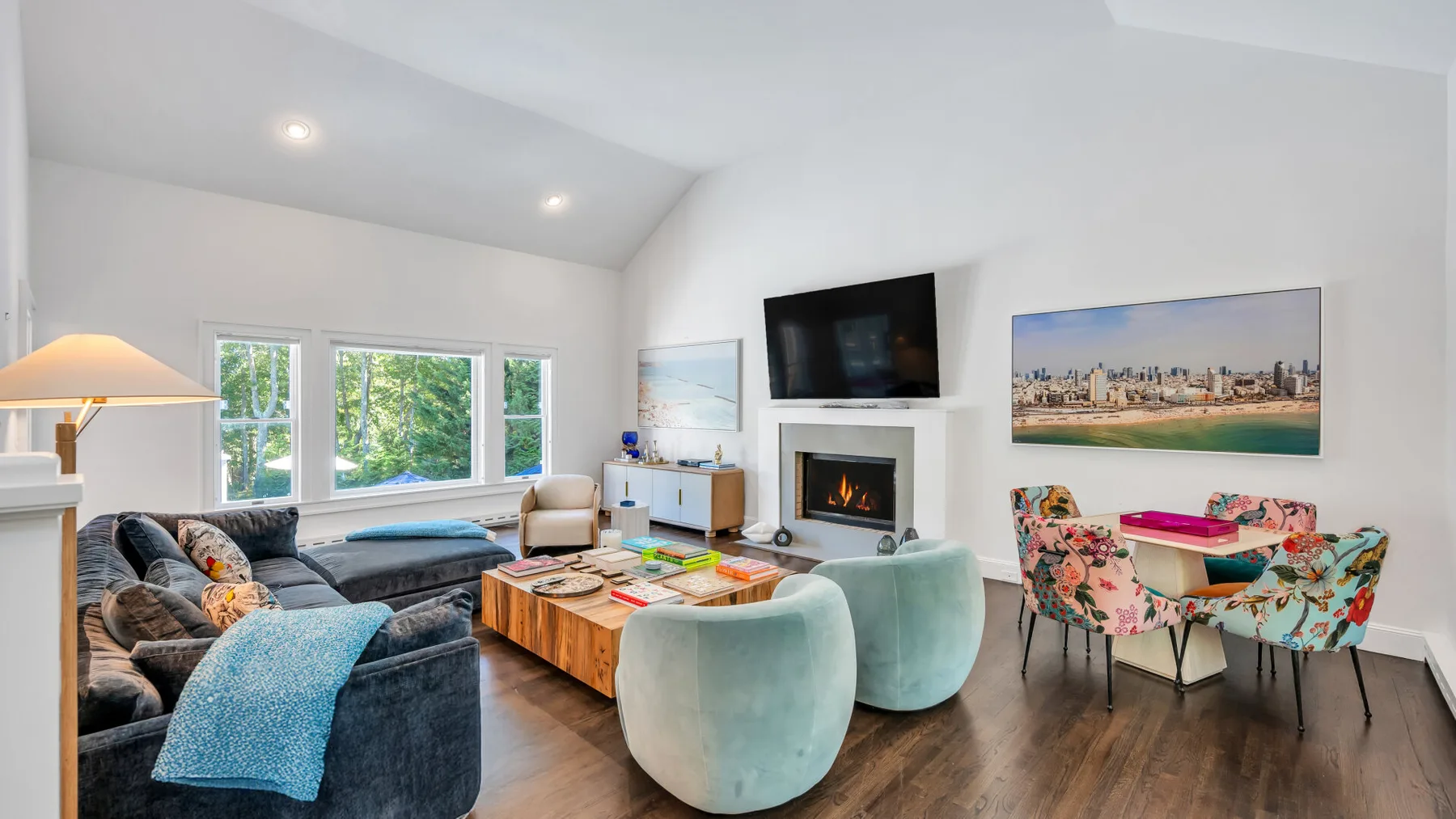 A bright living room with seating around a coffee table and a fireplace.