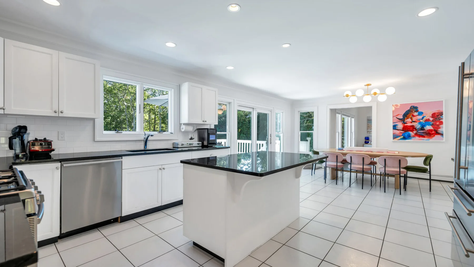 A bright kitchen with a central island and a dining table by the windows.