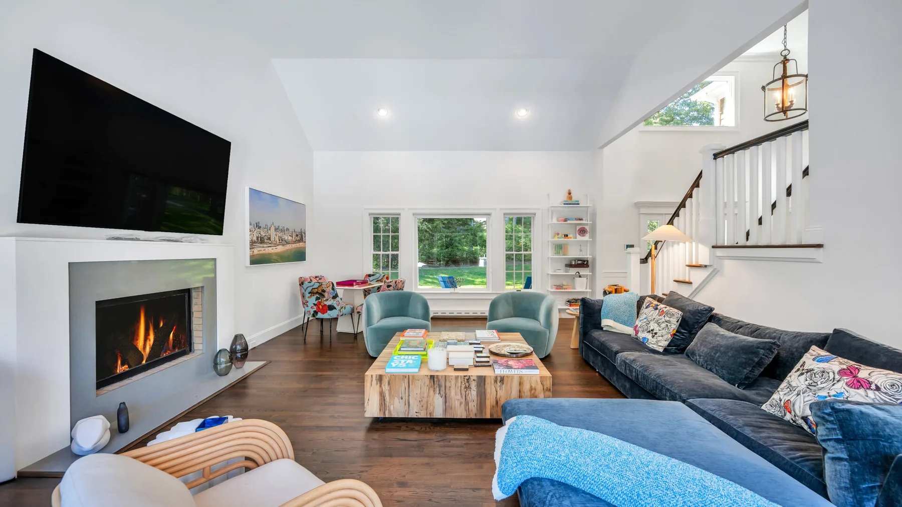A bright living room with a fireplace, seating, and a coffee table.