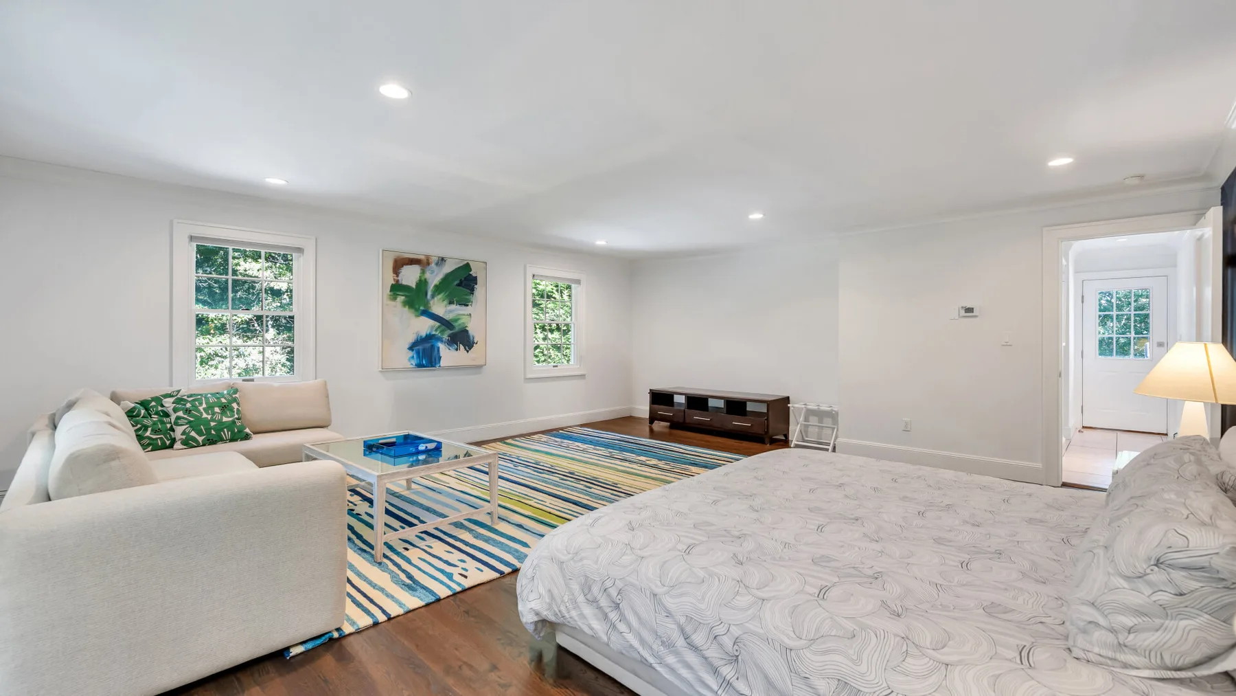 A bright living room with a sofa, patterned rug, and low table.