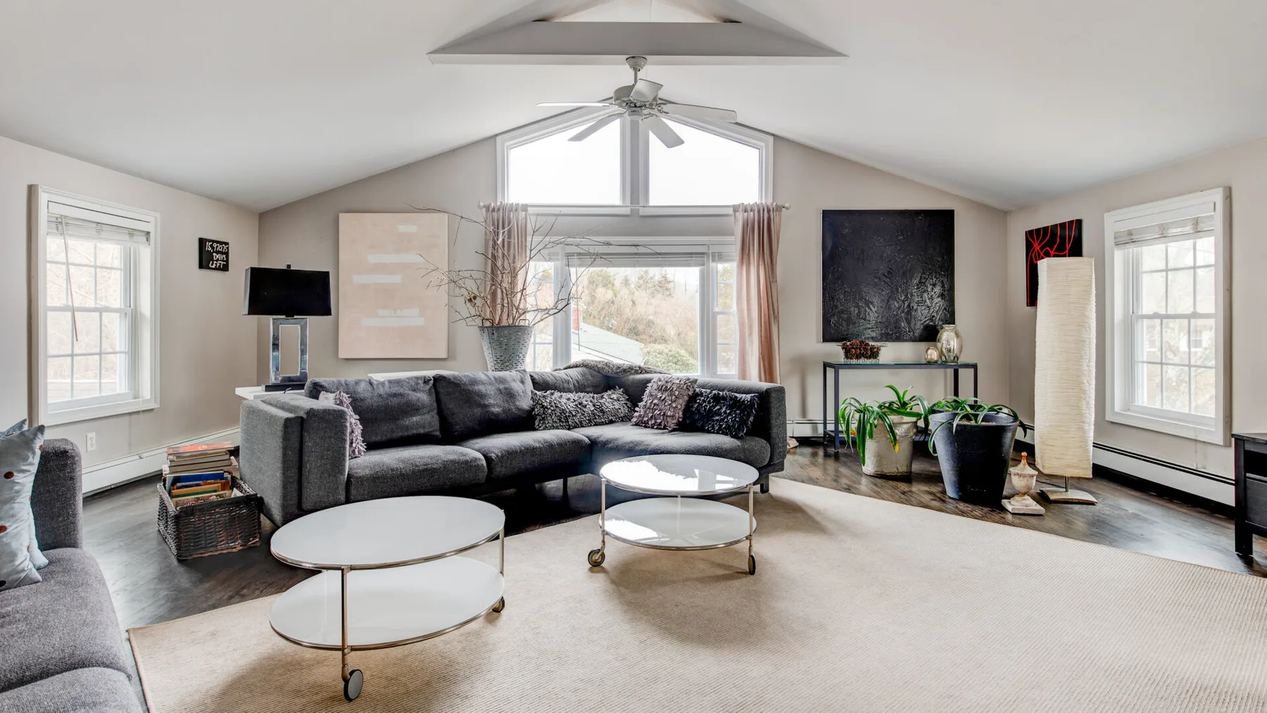 A bright living room with a sectional seating area and large windows.