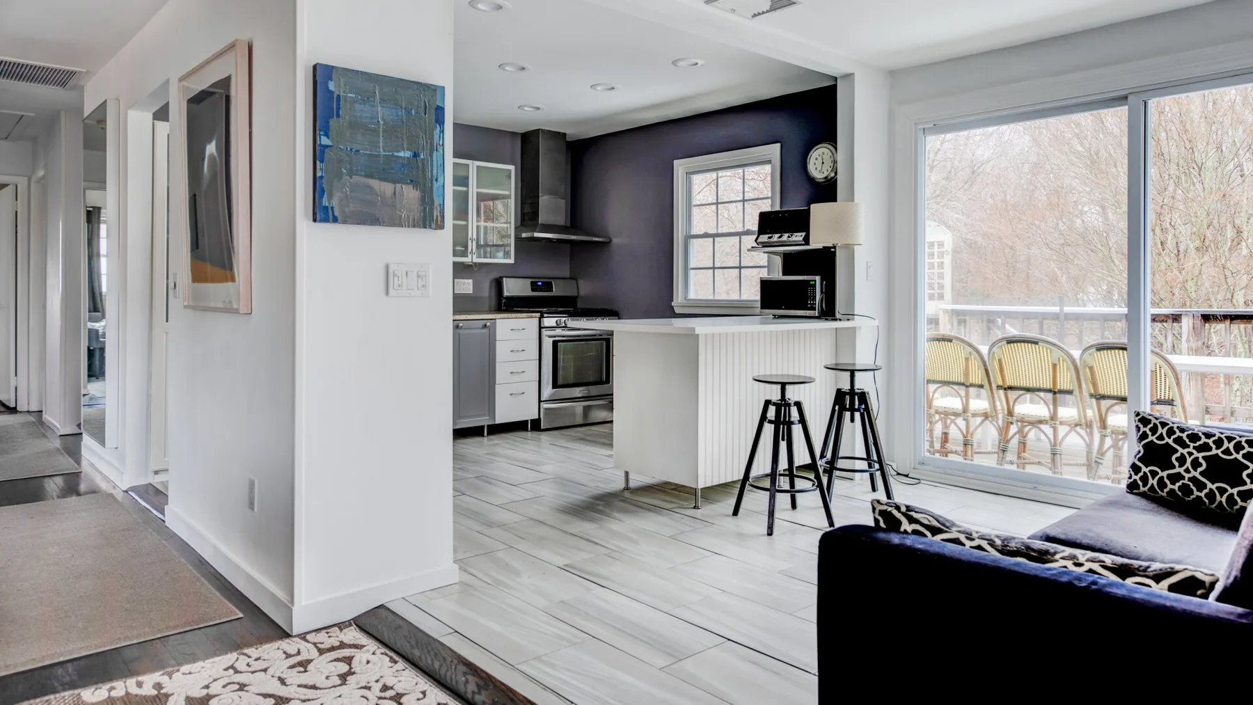 An open-plan kitchen and living area with a breakfast counter and large glass doors.