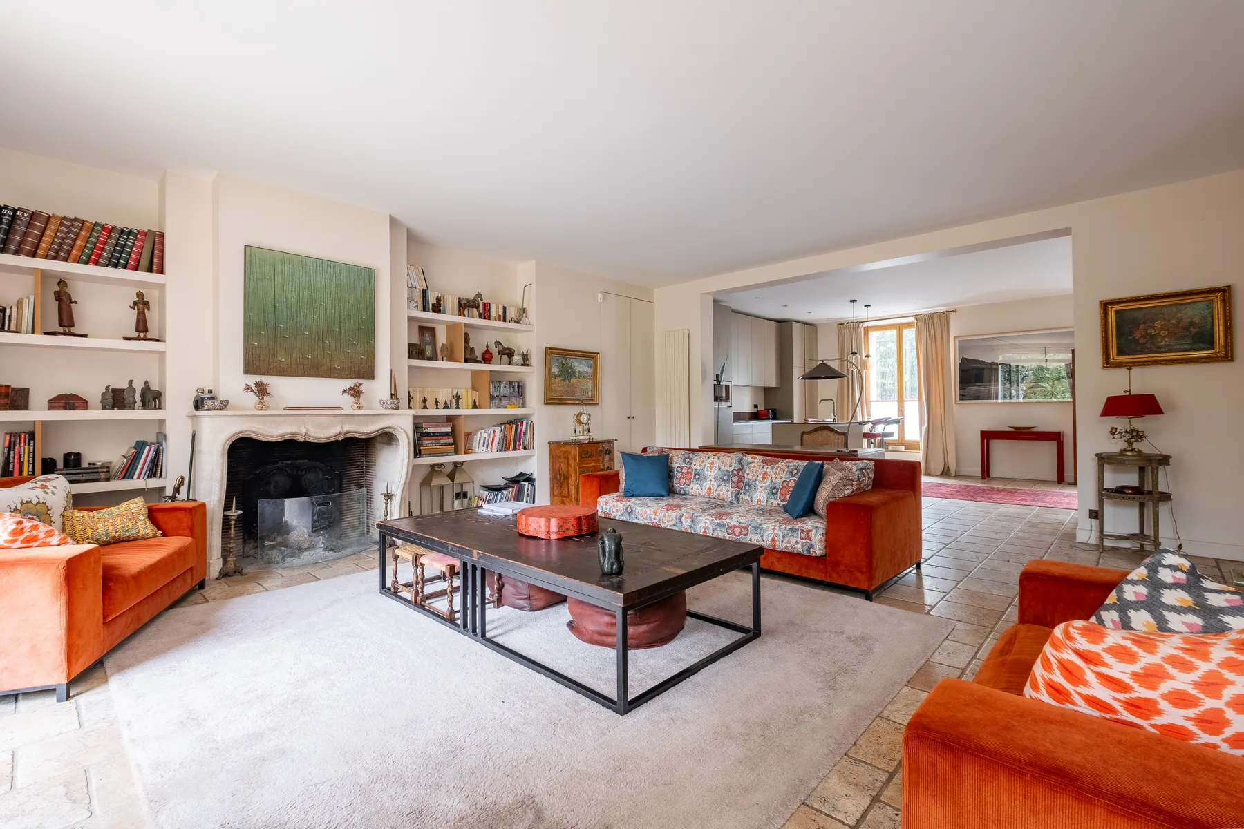 Una sala de estar con asientos alrededor de una mesa baja y una chimenea.