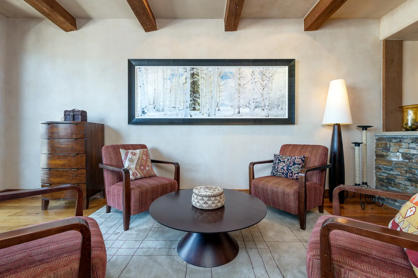 A living room with upholstered seating, a round coffee table, and framed artwork.