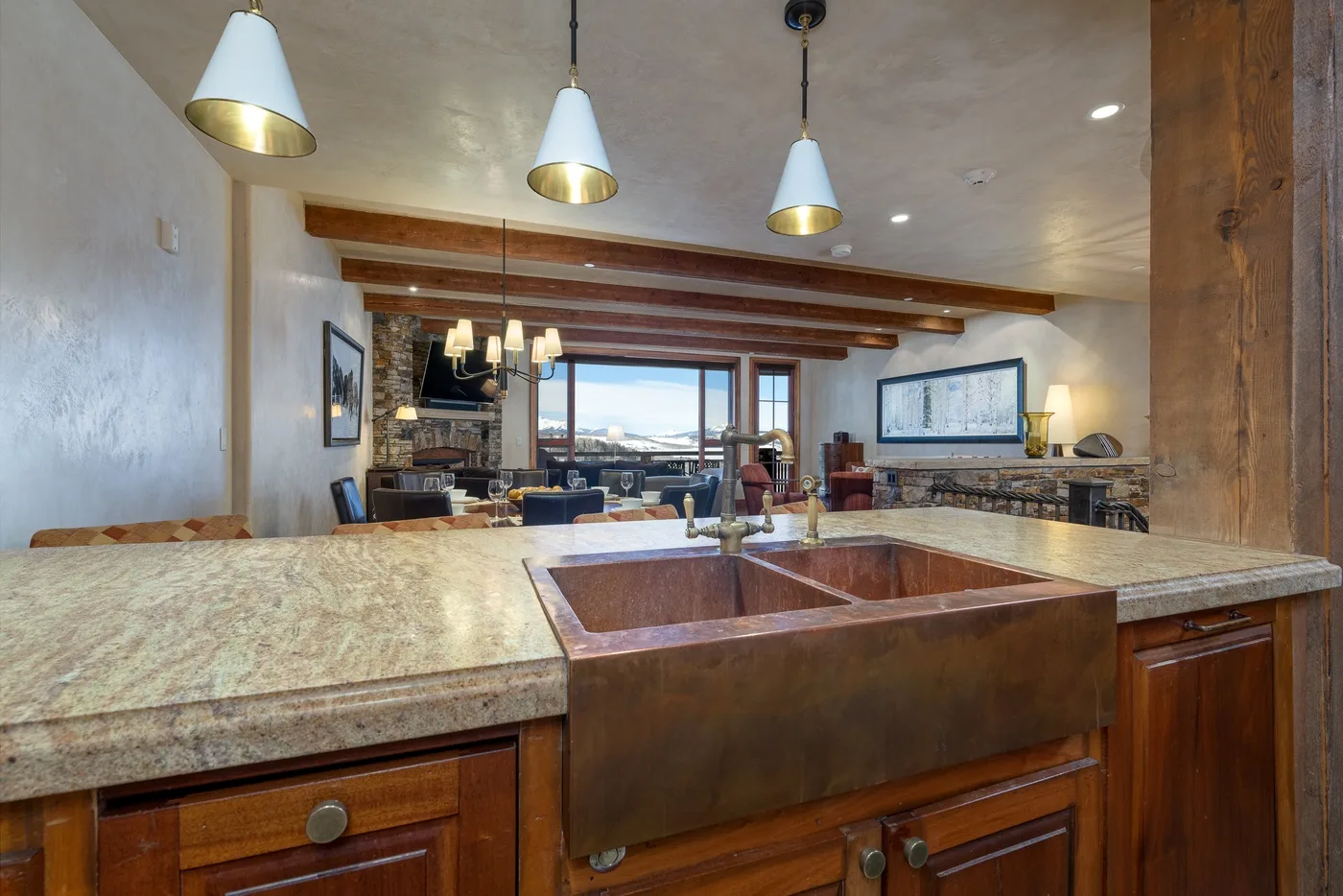 A kitchen island with a large sink overlooks an open living area.