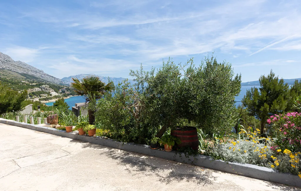 Un jardín en una terraza ajardinada ofrece vistas al mar y a las colinas.