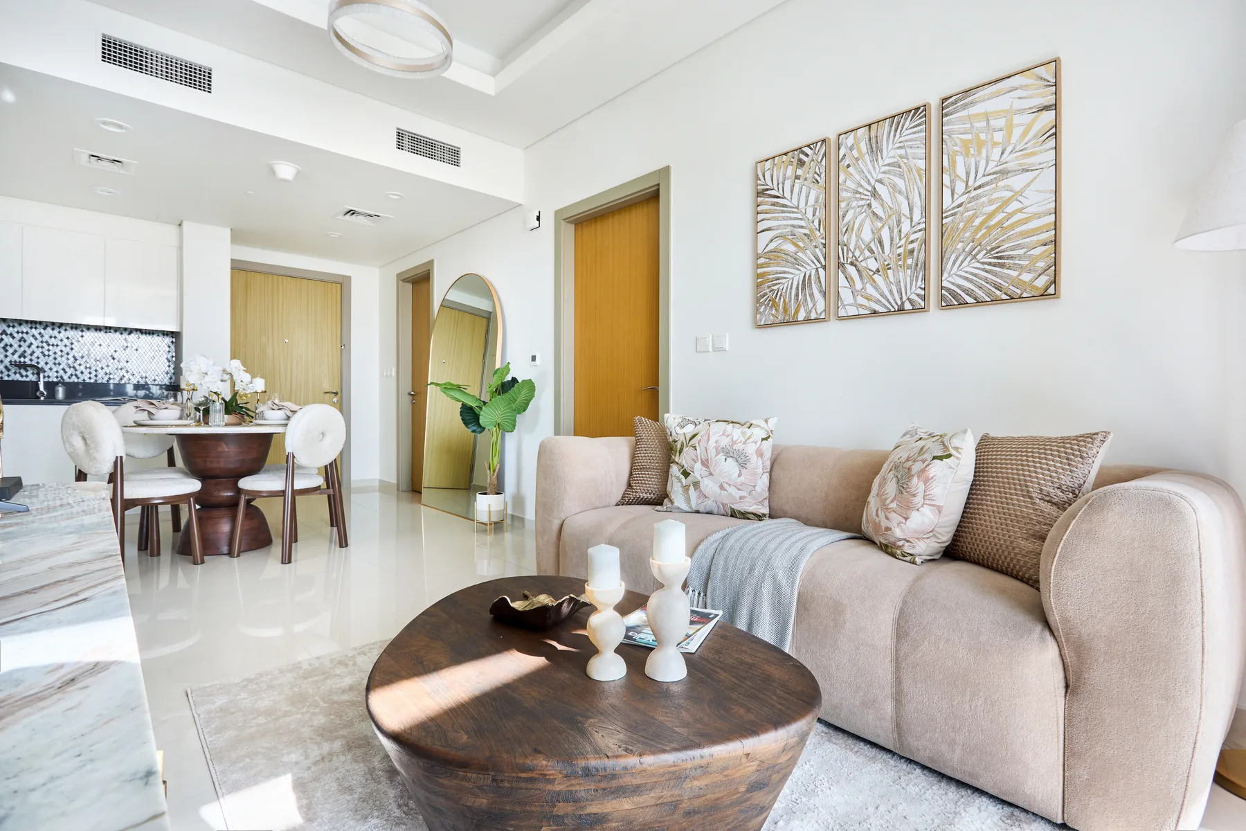 A bright living room with a beige sofa and a round coffee table.