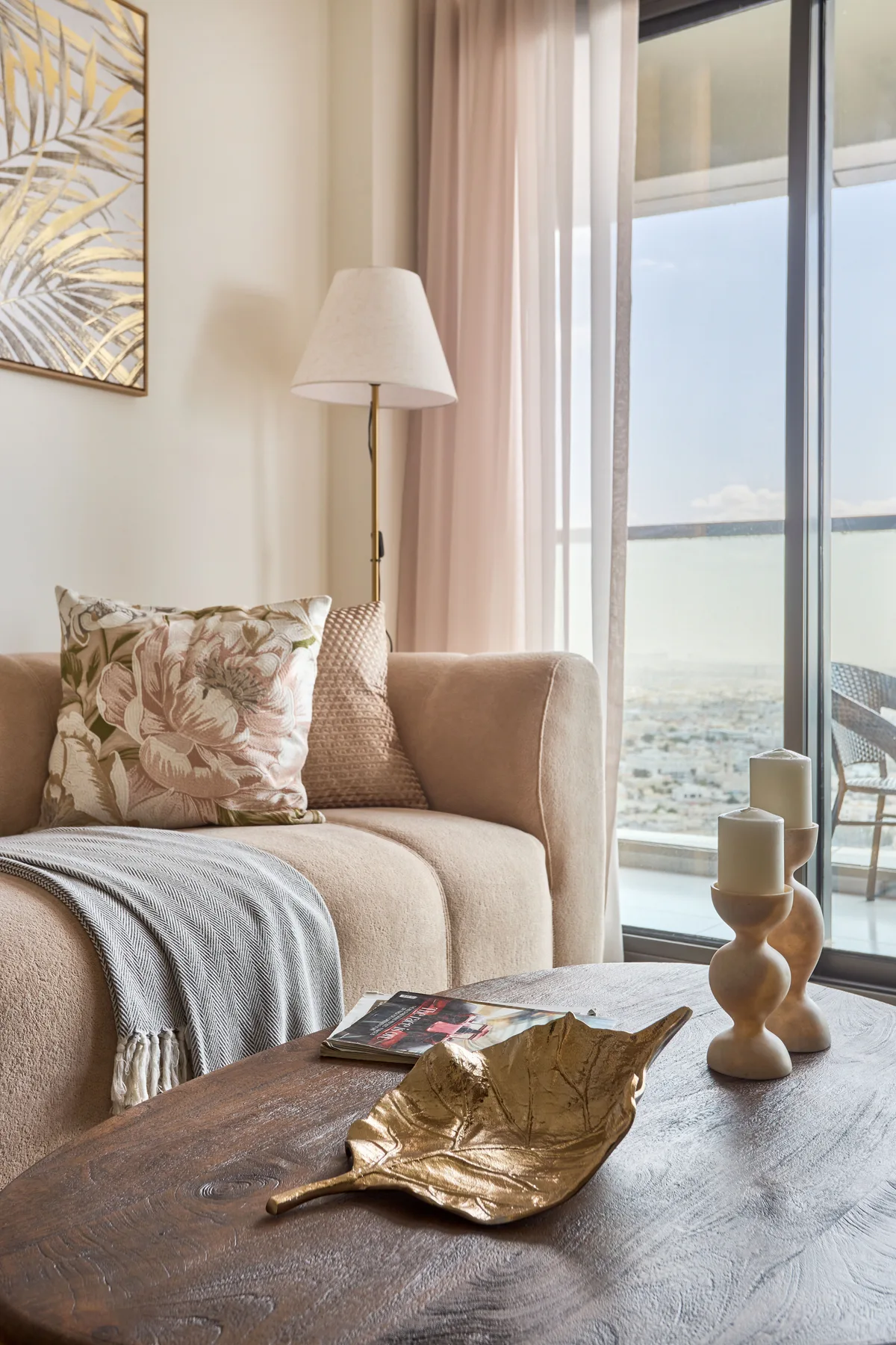 A living room seating area with a coffee table beside a large window.