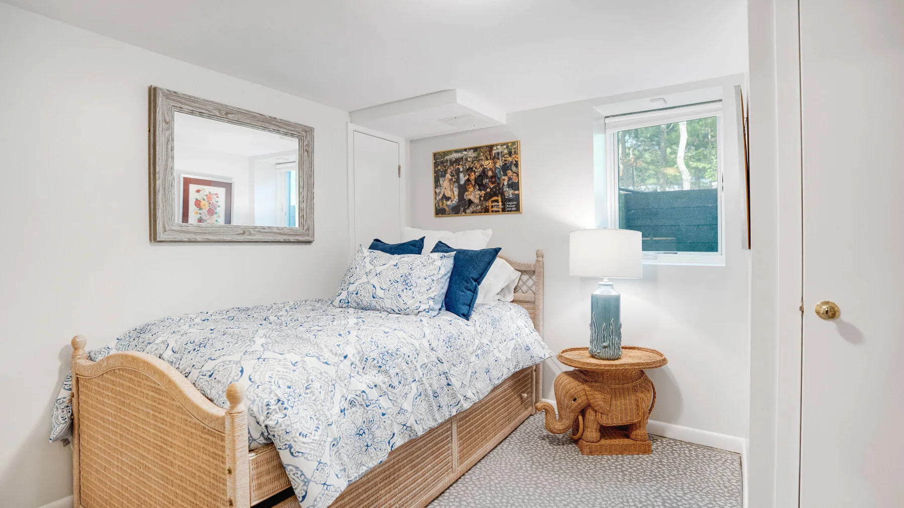 Un dormitorio con una cama junto a una mesita redonda y una ventana.
