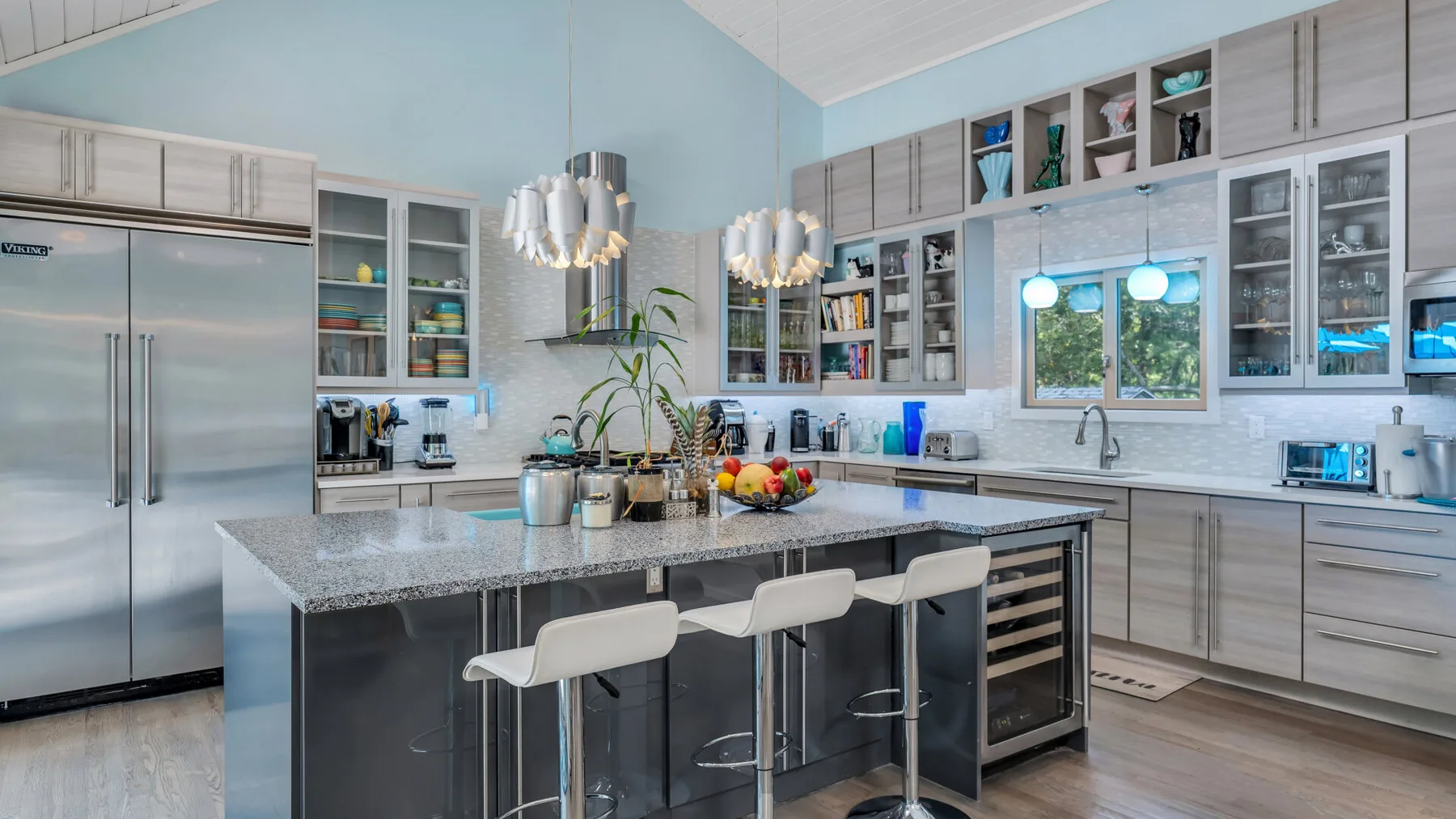 Una cocina luminosa con una isla grande y abundantes gabinetes.
