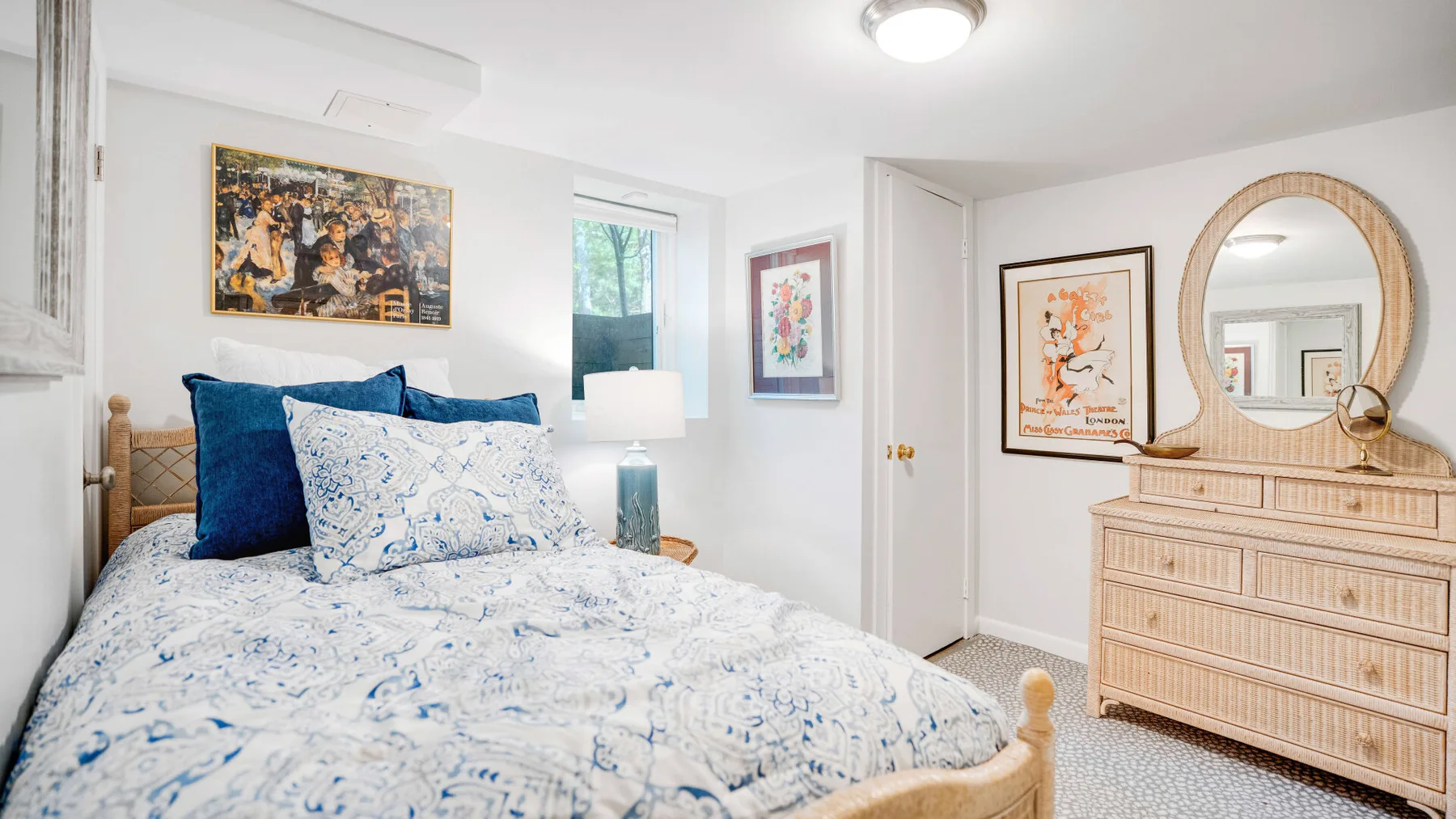 Un dormitorio con una cama cubierta con ropa de cama estampada en azul y blanco.