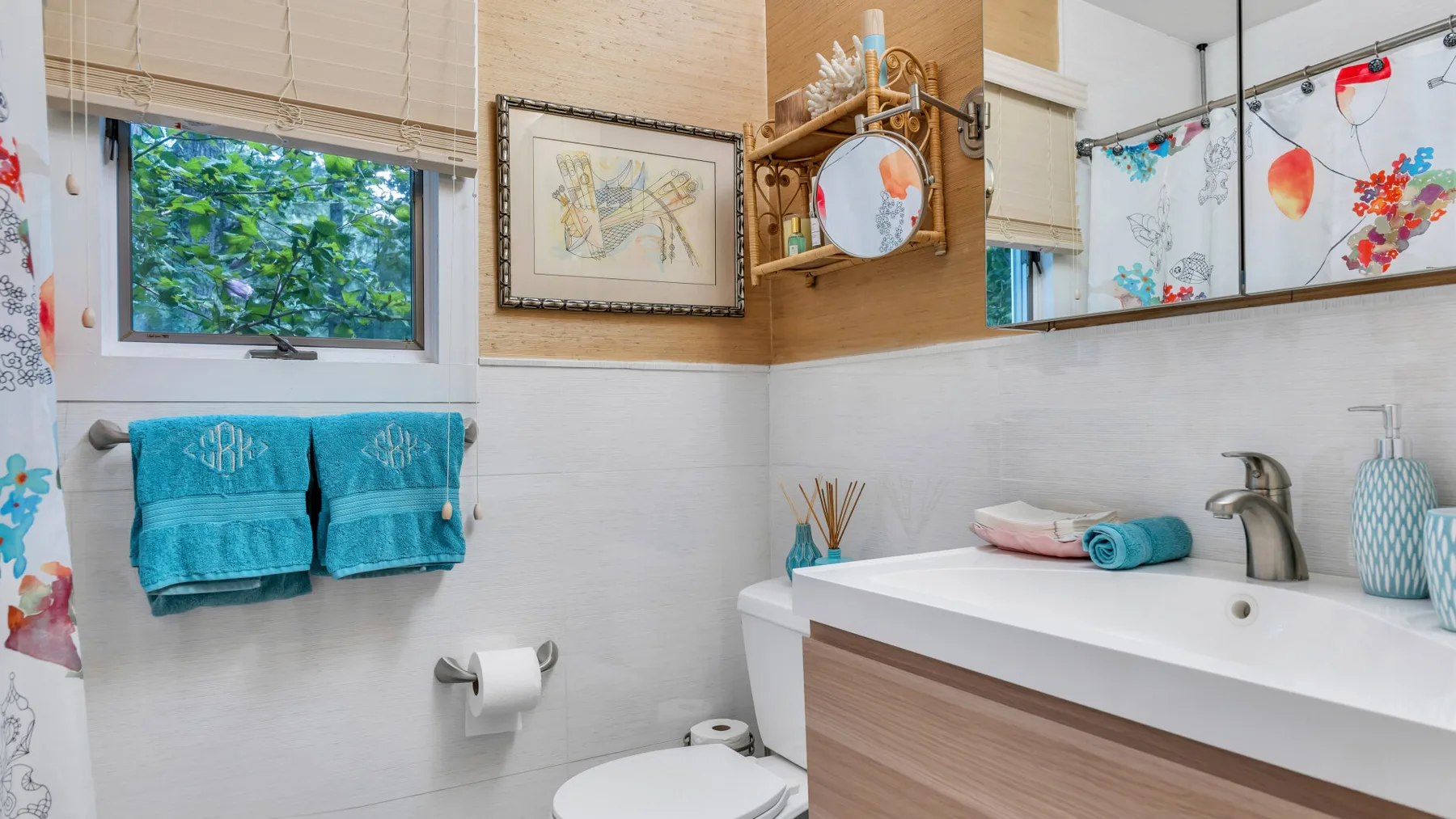 Un baño colorido con un lavabo amplio, un espejo de pared y toallas.