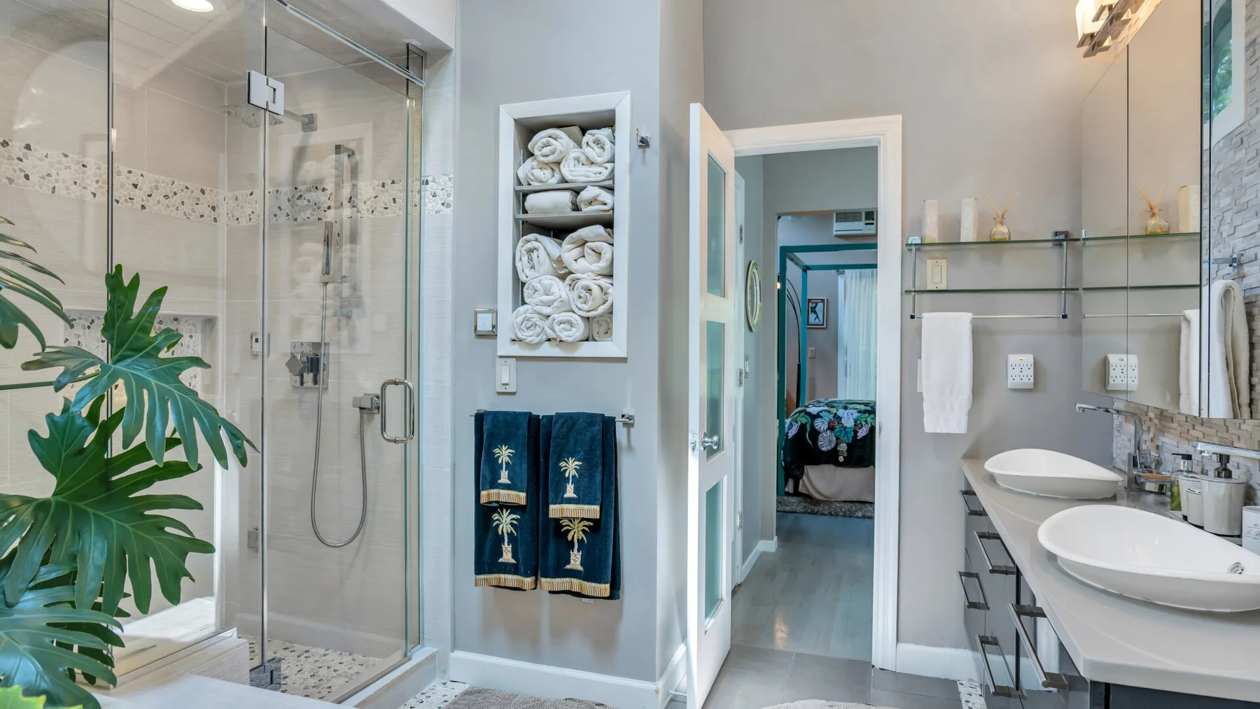 Un baño con una ducha de vidrio y dos lavabos sobre la encimera.