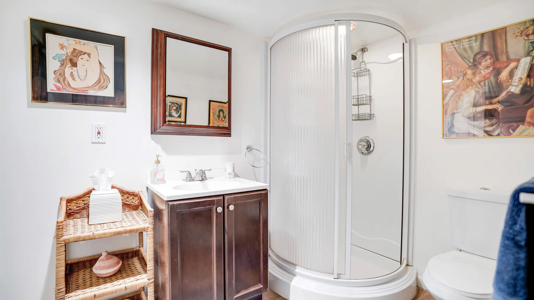 Un baño con lavabo, ducha curva de vidrio e inodoro.