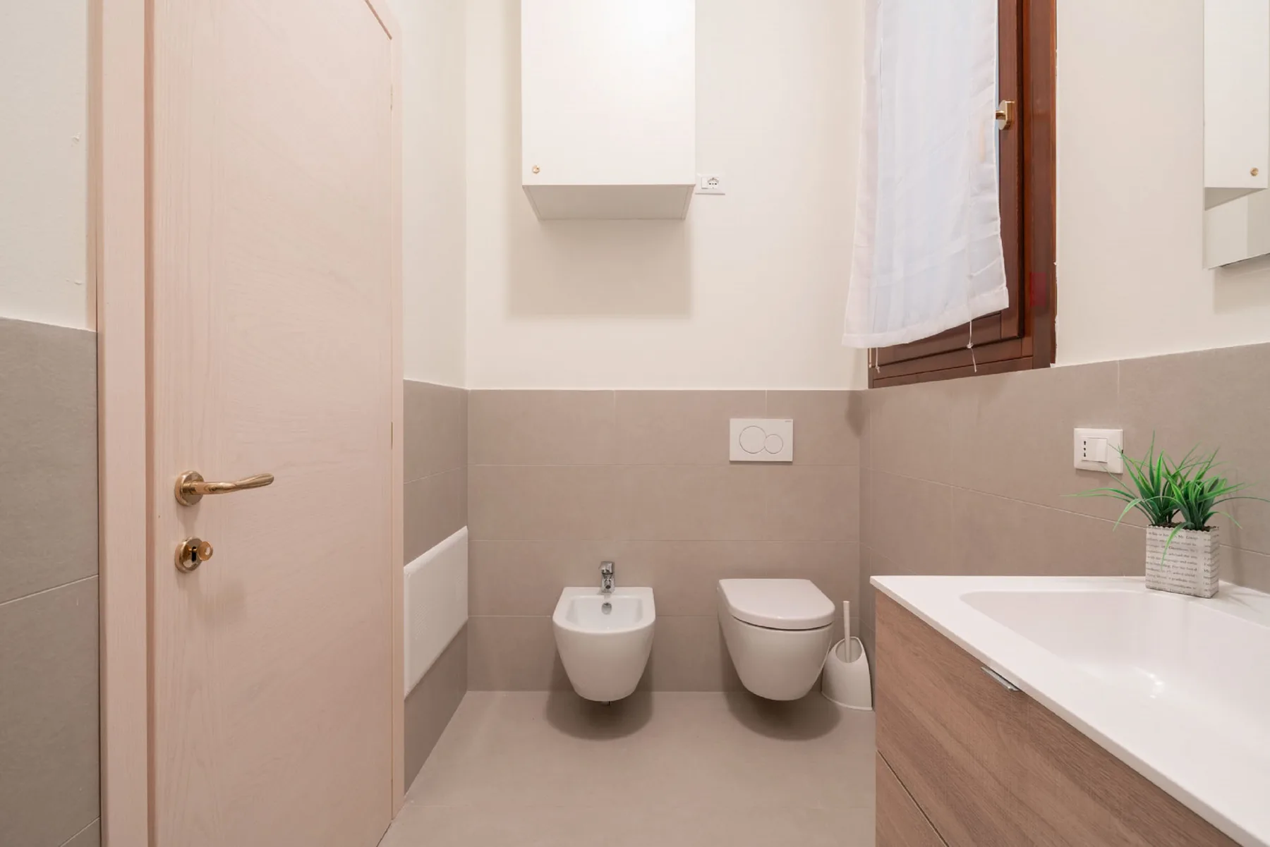 A bathroom with a bathtub, bidet, and toilet.