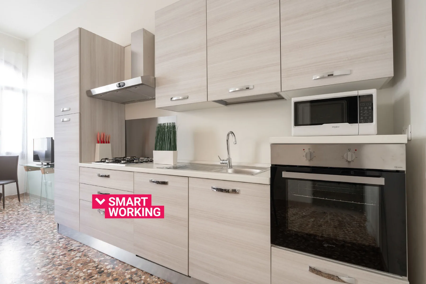 A modern kitchen with light cabinetry, a cooktop, and built-in appliances.