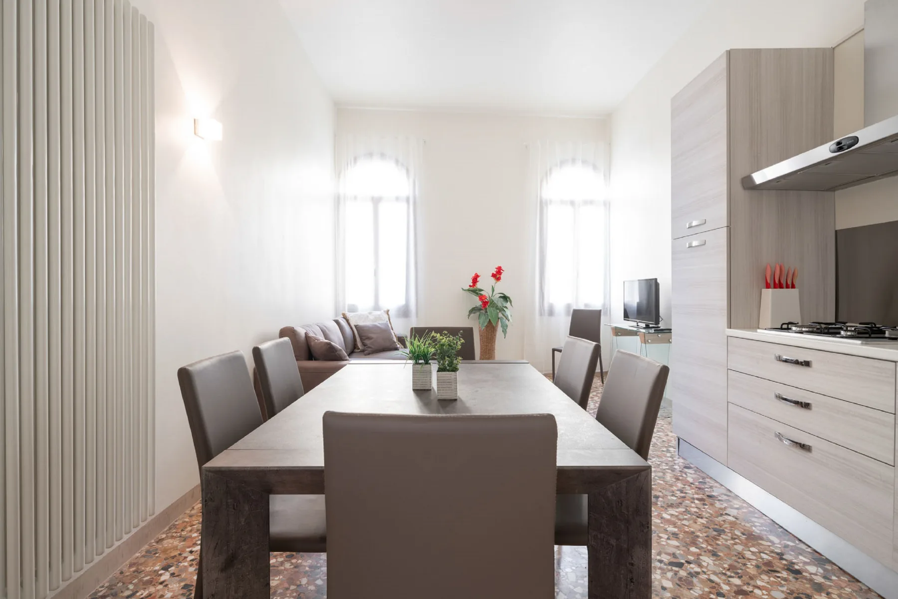 A bright dining area with a long table and large windows.