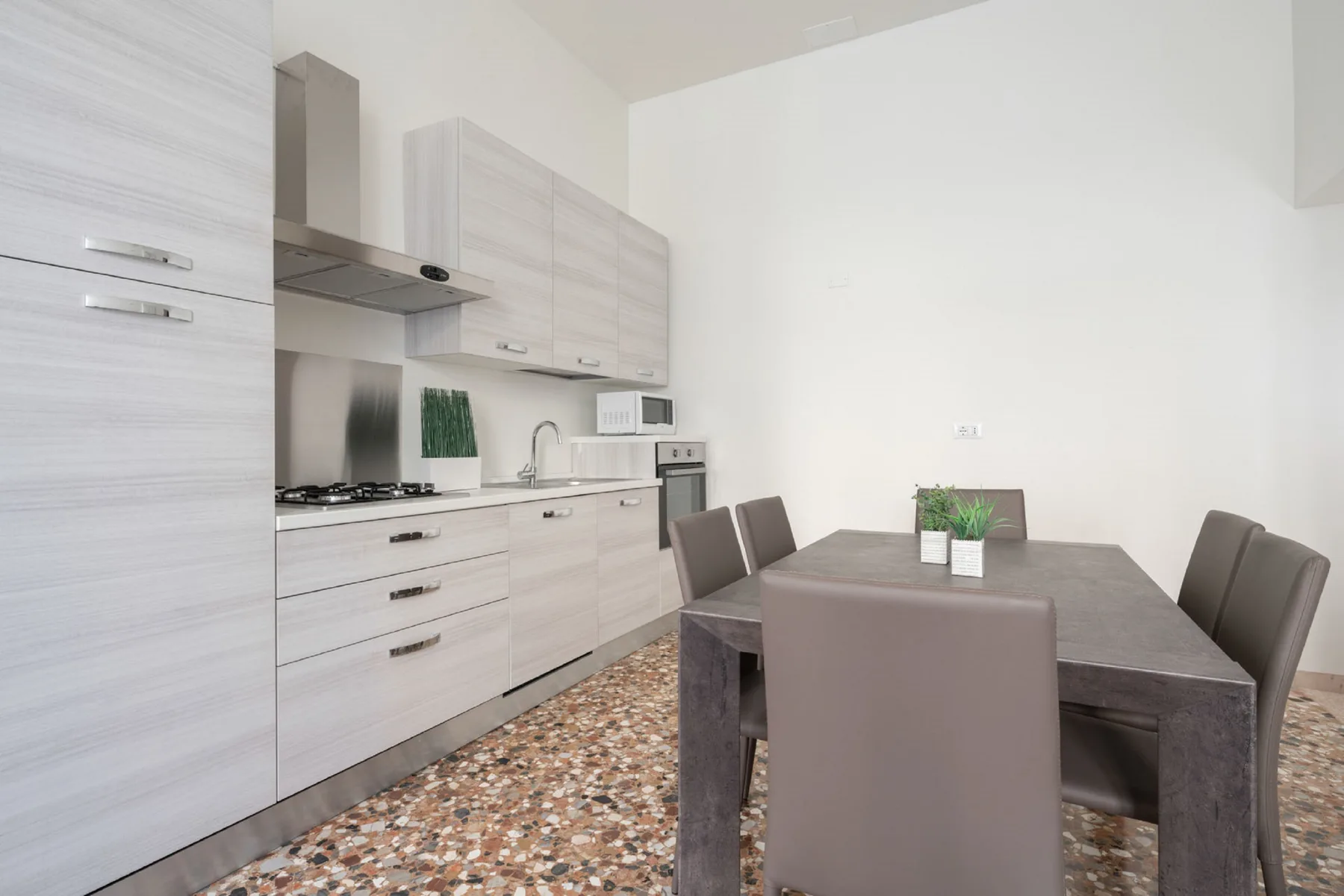 A dining area with a table and chairs beside a kitchen.