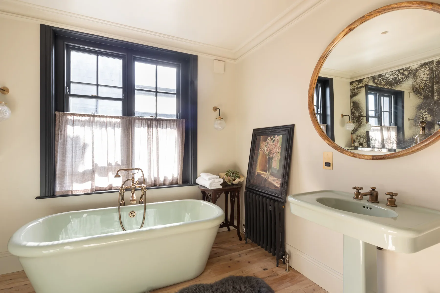 A bright bathroom with a freestanding tub and a sink.