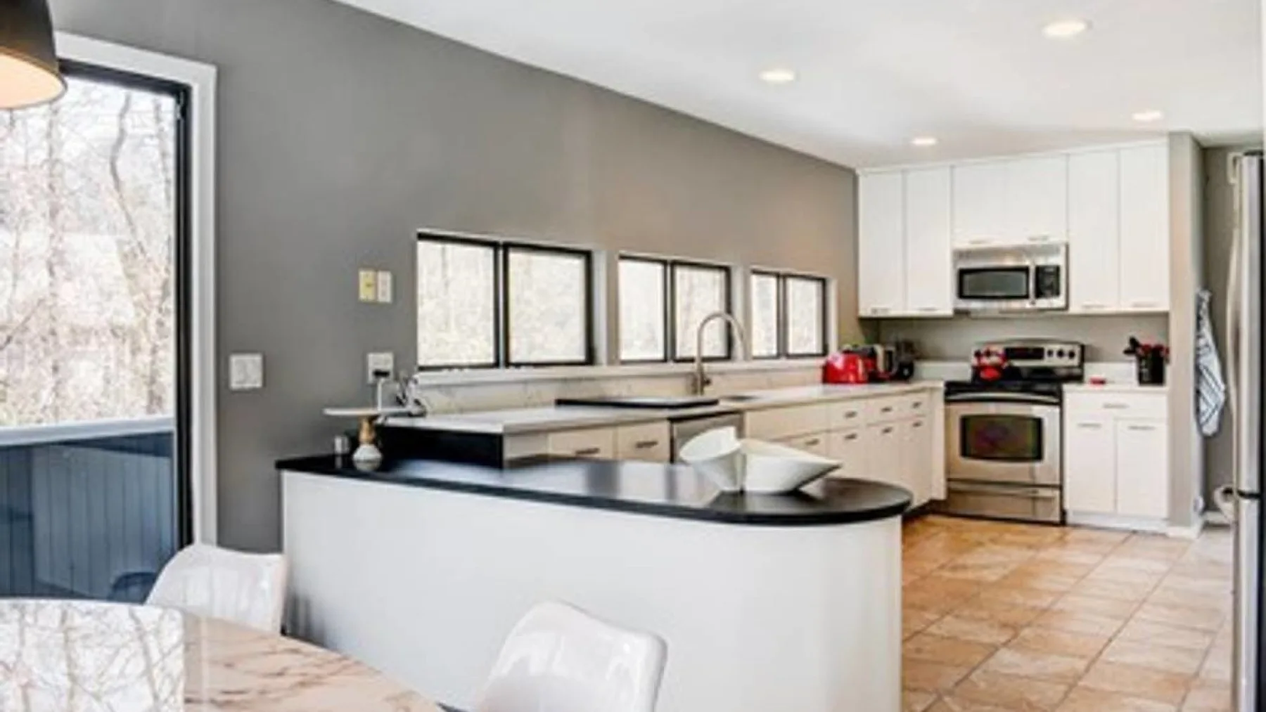 A bright kitchen with white cabinets and a central island.