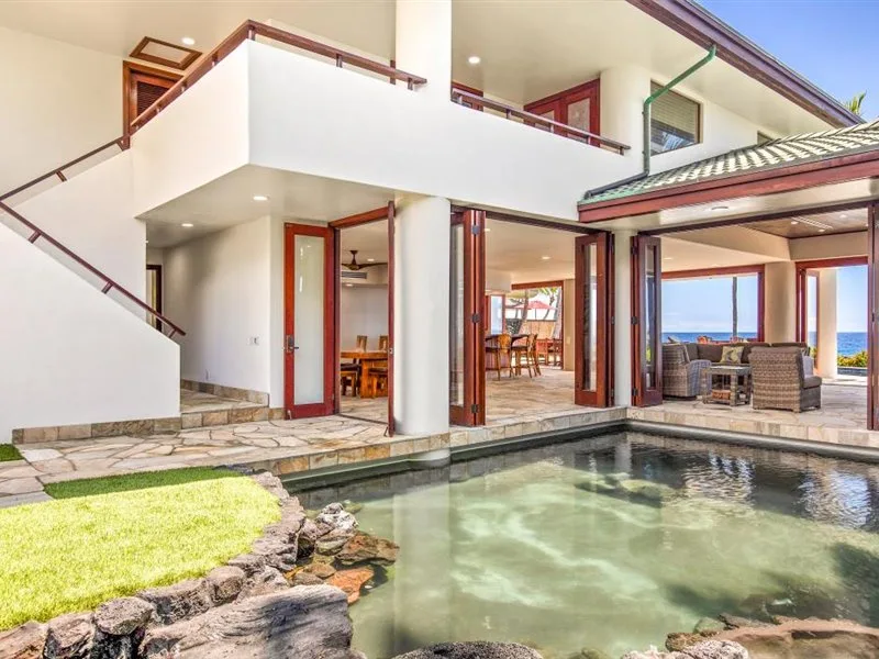 Una casa moderna da a una piscina y un patio cubierto.