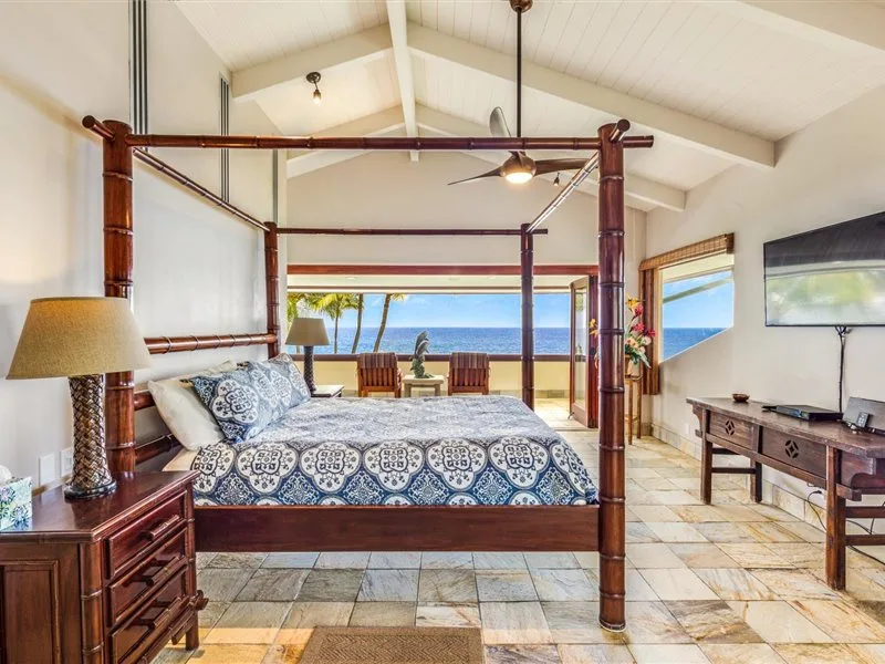 Un dormitorio con una cama grande frente a una vista abierta al mar.
