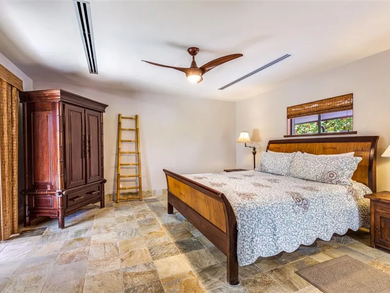 Un dormitorio con una cama de madera y ropa de cama estampada.
