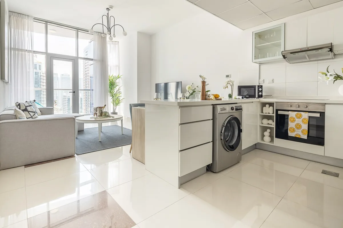 Una luminosa cocina abierta a la sala de estar, con ventanas grandes.