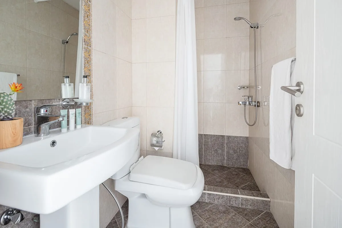 Un baño alicatado con lavabo, inodoro y ducha.