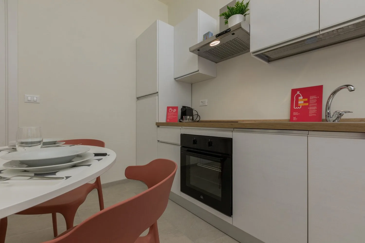 A compact kitchen with a dining table and chairs beside the counter.