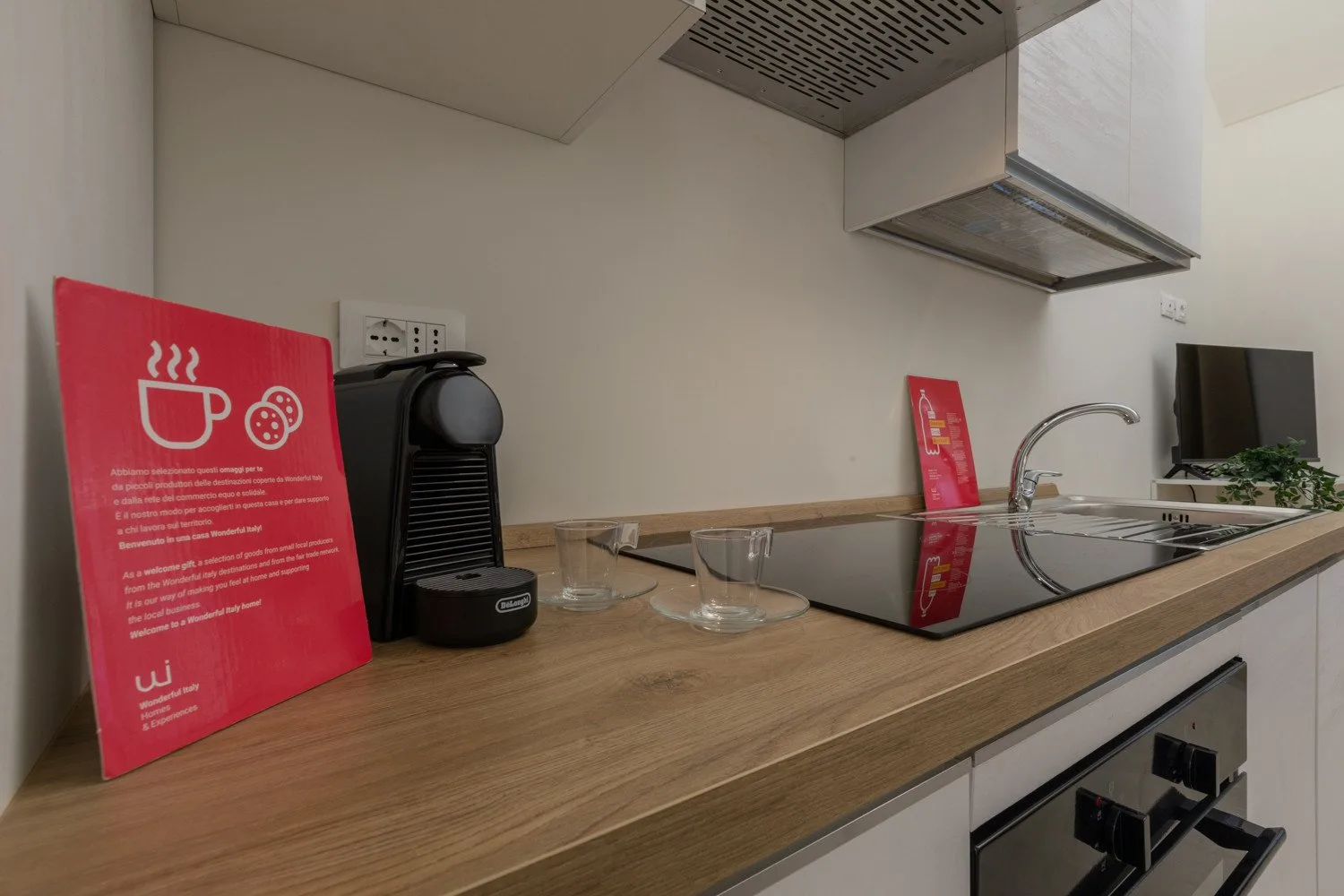 A kitchen counter with a coffee machine, cooktop, and sink.