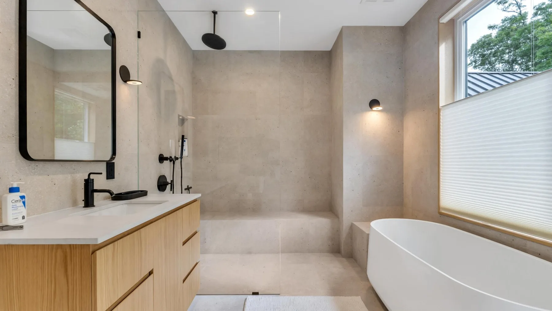 A modern bathroom with a bathtub, walk-in shower, and wood vanity.