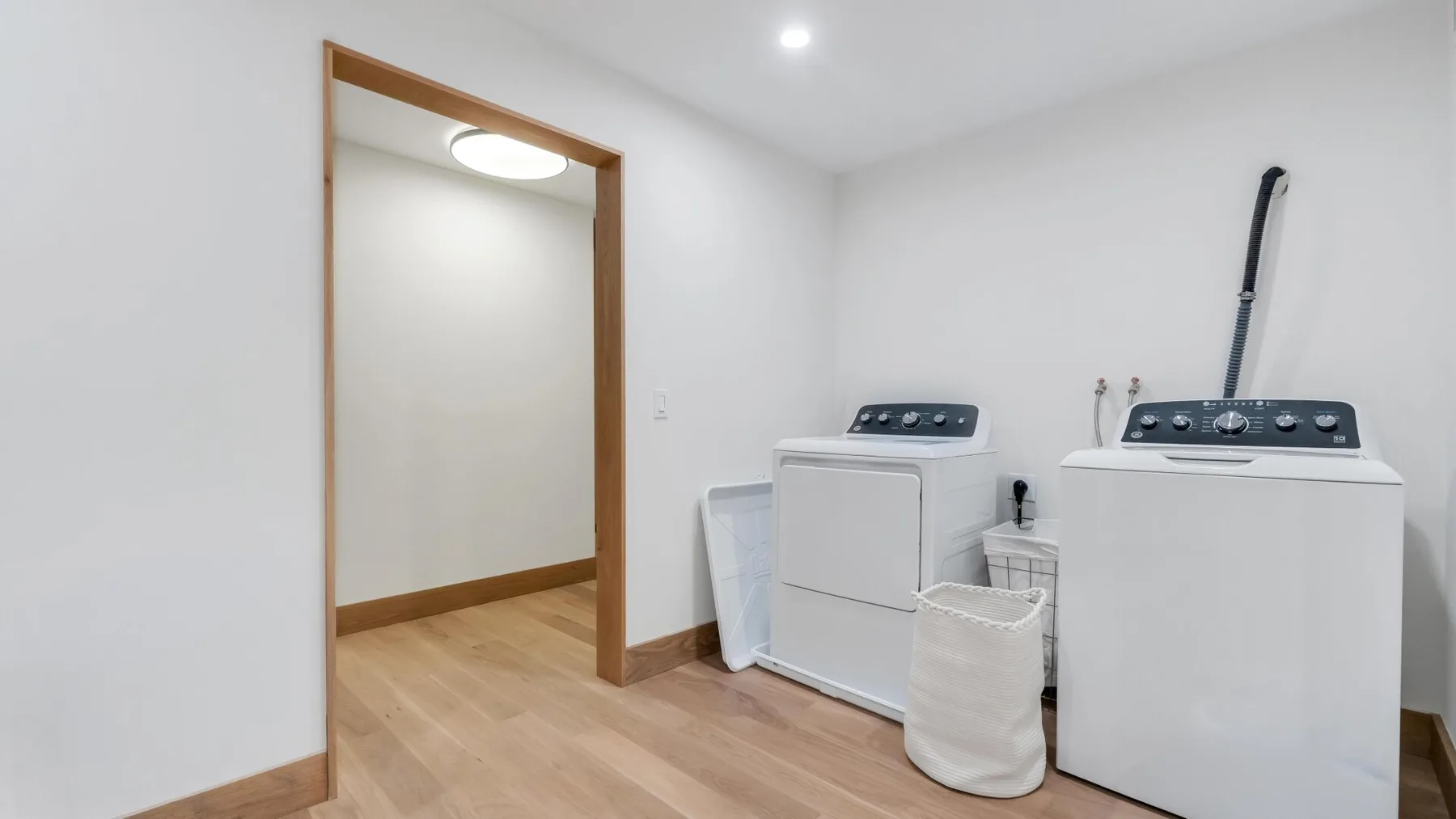 A laundry room with a washer, dryer, and laundry basket.