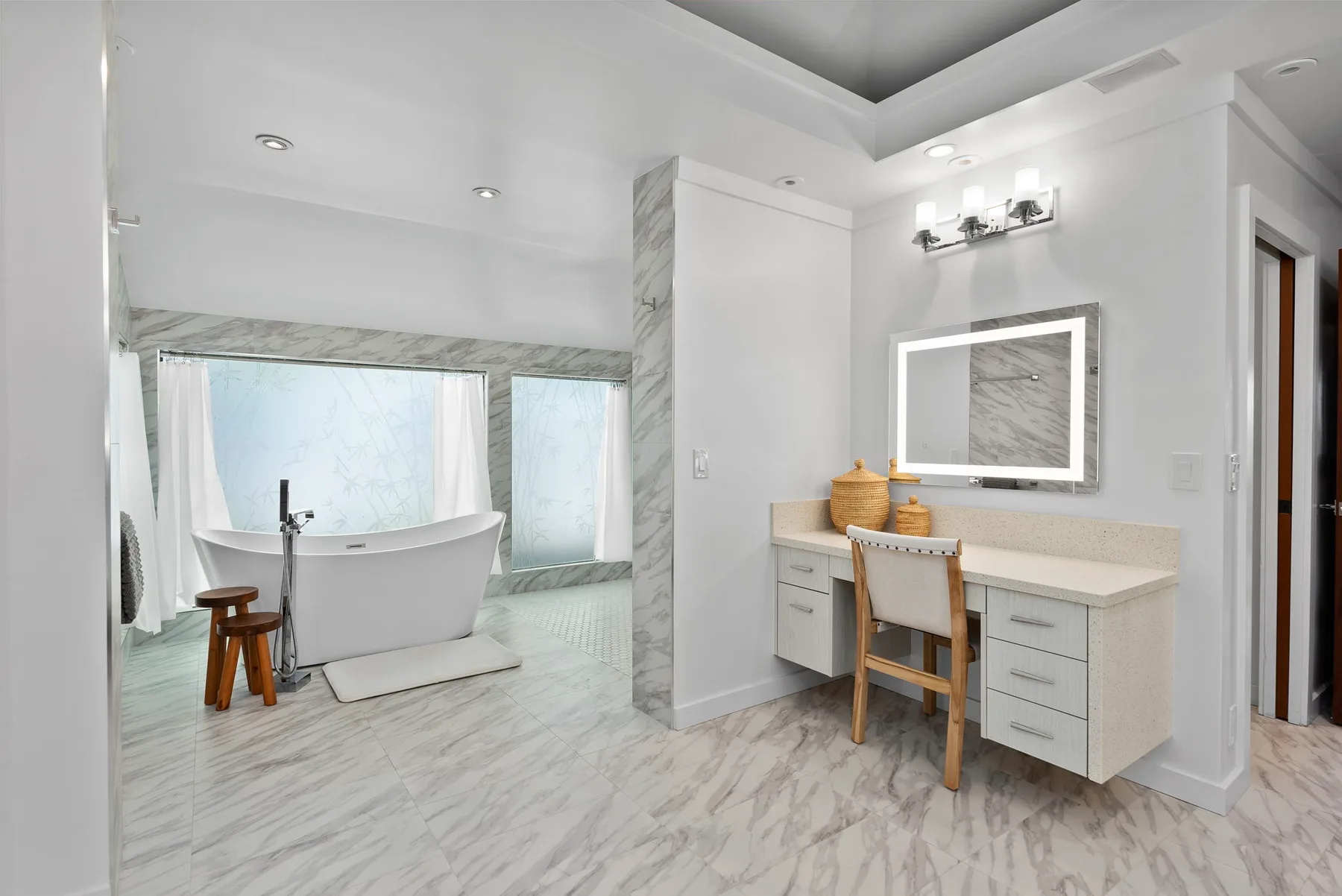 Un baño luminoso con una bañera exenta y un tocador con espejo.