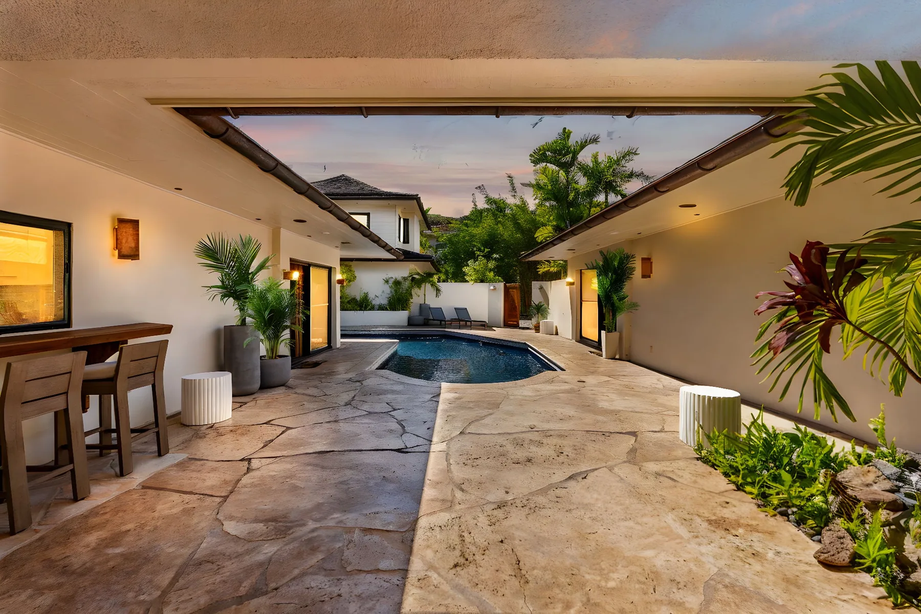 Un patio exterior con piscina, pavimento y asientos a un lado.