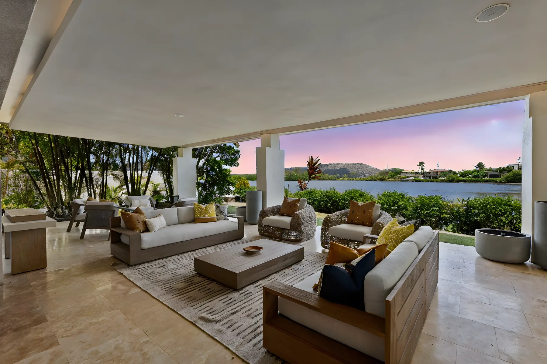 An open-air lounge with cushioned seating and a view of the water.