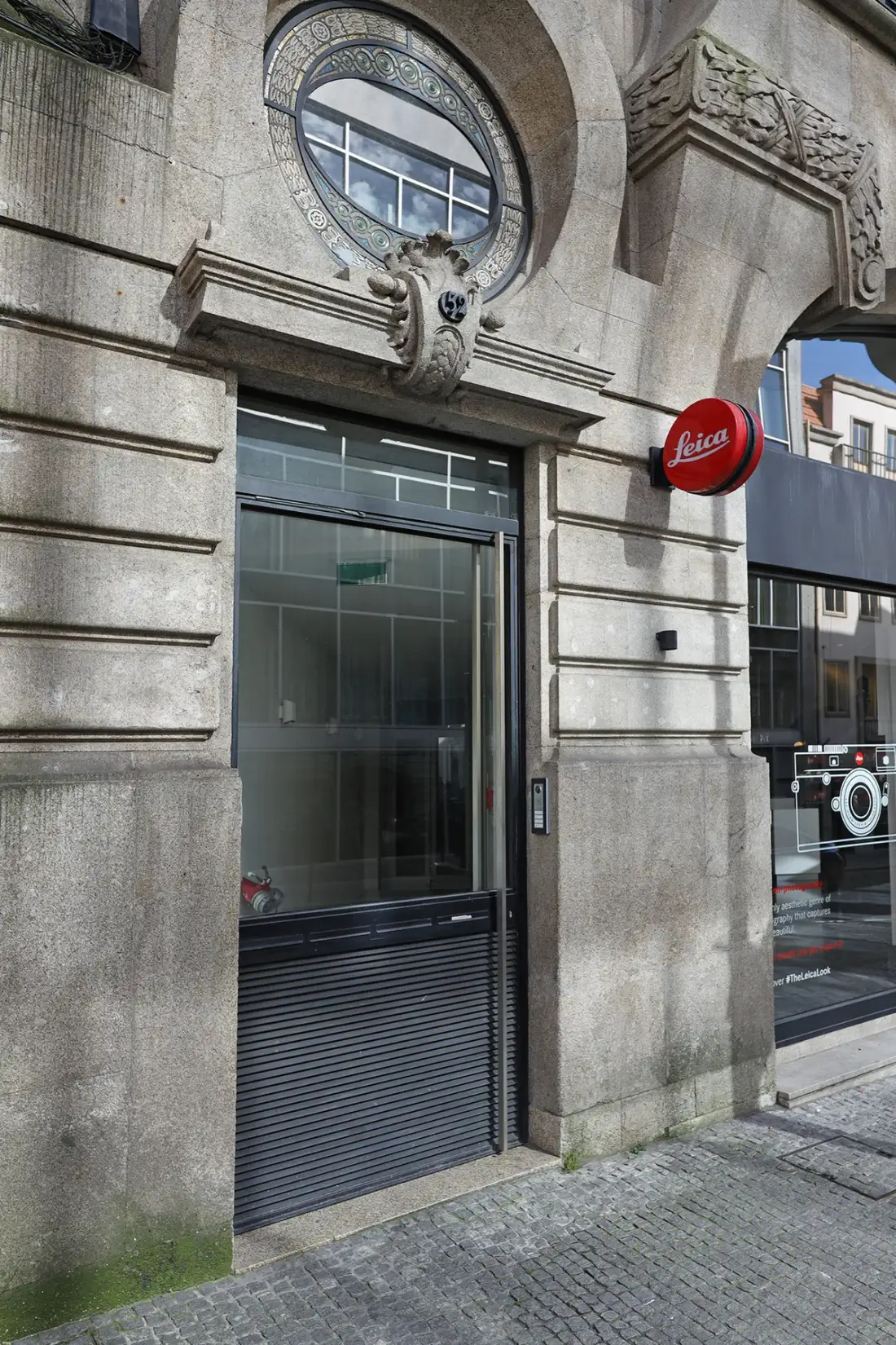 Una entrada a nivel de calle con una ventana redonda sobre la puerta.