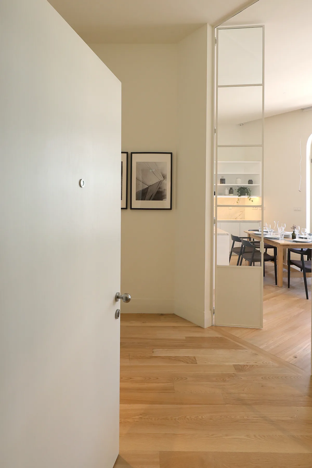 Una puerta abierta da a un comedor con una mesa y sillas.